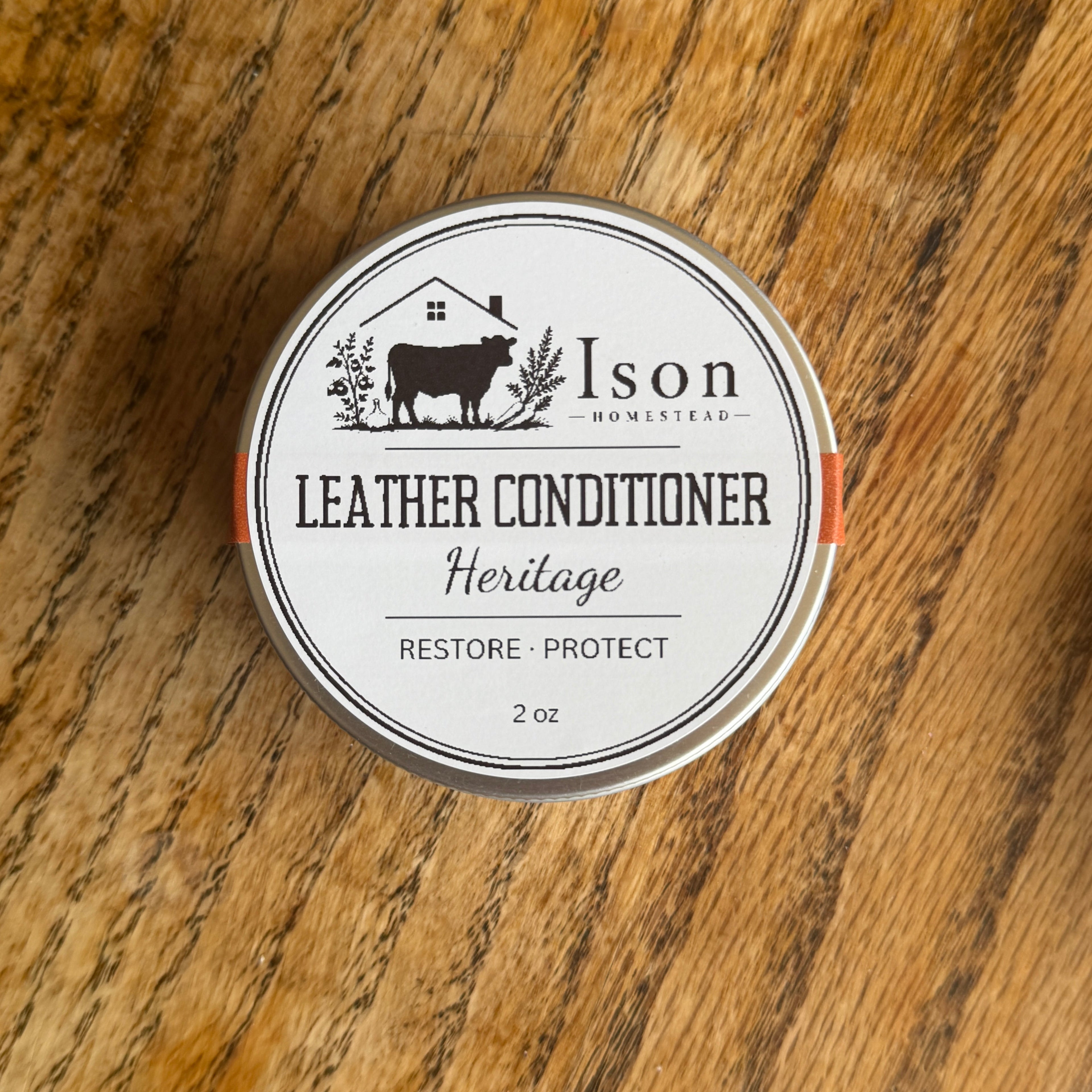 Ison Leather Conditioner tin on a wooden surface