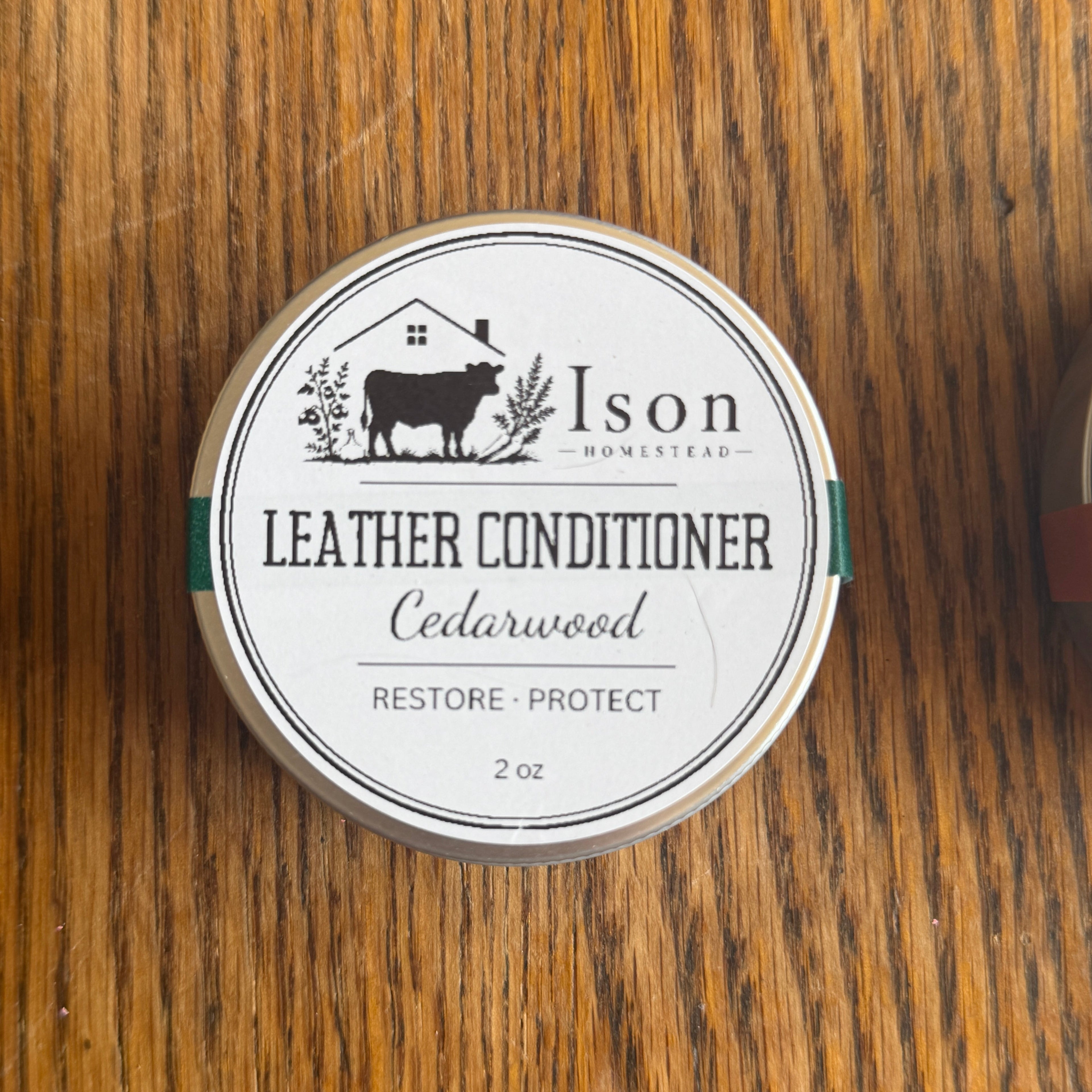 Ison Leather Conditioner container on a wooden surface